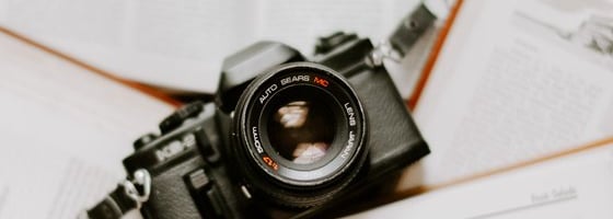 black nikon dslr camera on white printer paper