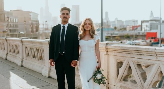 man in black suit standing beside woman in white wedding dress