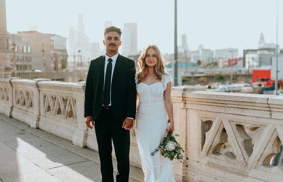man in black suit standing beside woman in white wedding dress