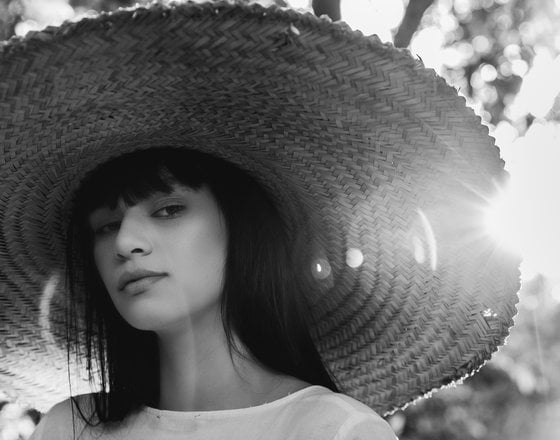 woman in white crew neck shirt wearing brown sun hat