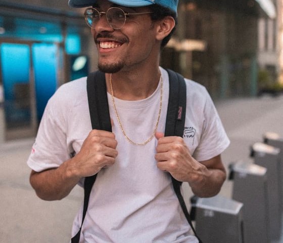 man in white crew neck t-shirt wearing blue cap and black sunglasses