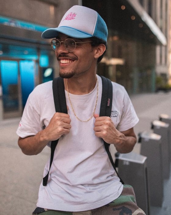 man in white crew neck t-shirt wearing blue cap and black sunglasses