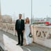 man in black suit standing beside woman in white wedding dress