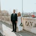 man in black suit standing beside woman in white wedding dress