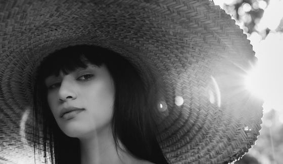 woman in white crew neck shirt wearing brown sun hat