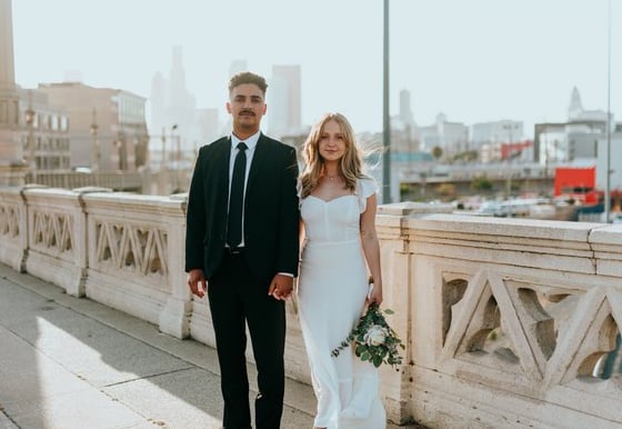 man in black suit standing beside woman in white wedding dress