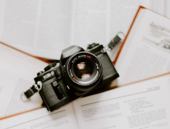 black nikon dslr camera on white printer paper