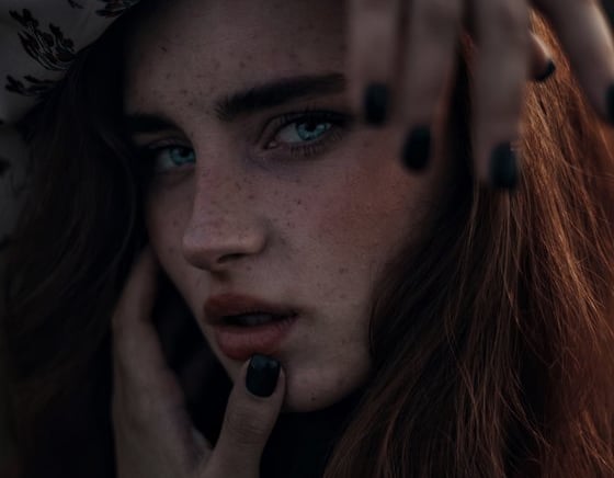 woman with brown hair wearing white and black floral hijab