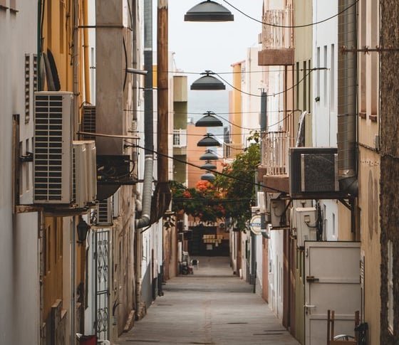 empty hallway between concrete buildings during daytime