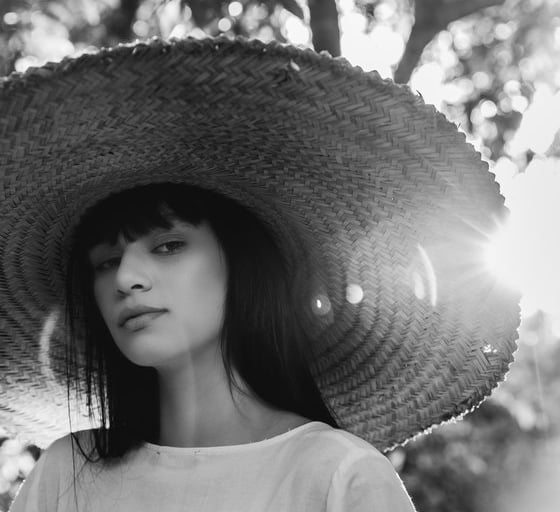 woman in white crew neck shirt wearing brown sun hat