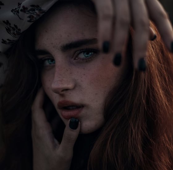 woman with brown hair wearing white and black floral hijab