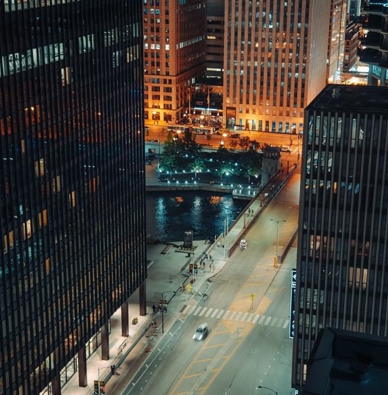 body of water between high rise buildings during night time