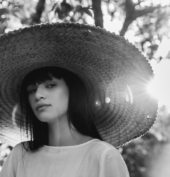 woman in white crew neck shirt wearing brown sun hat