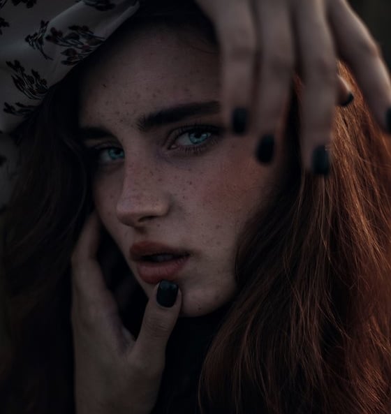 woman with brown hair wearing white and black floral hijab