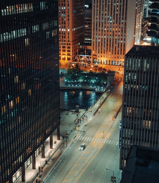 body of water between high rise buildings during night time