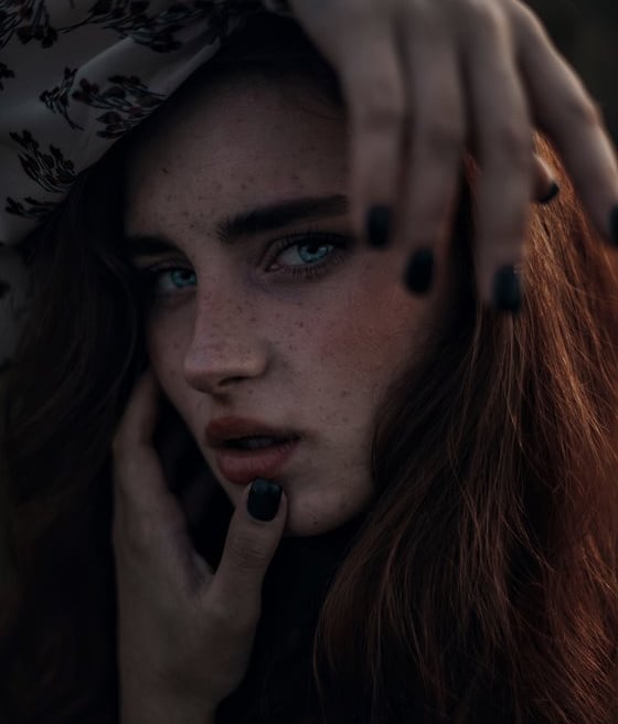 woman with brown hair wearing white and black floral hijab