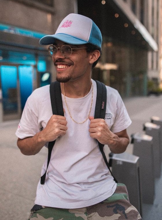man in white crew neck t-shirt wearing blue cap and black sunglasses