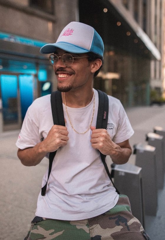 man in white crew neck t-shirt wearing blue cap and black sunglasses