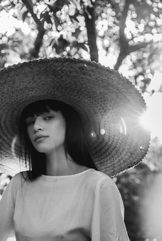 woman in white crew neck shirt wearing brown sun hat