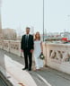man in black suit standing beside woman in white wedding dress