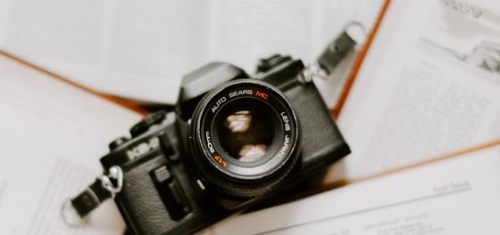black nikon dslr camera on white printer paper
