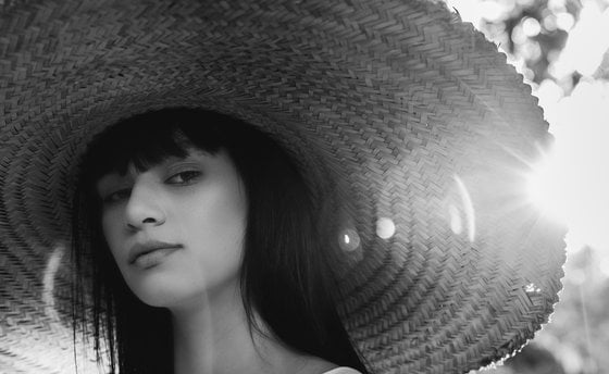 woman in white crew neck shirt wearing brown sun hat