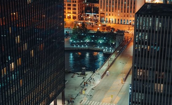 body of water between high rise buildings during night time