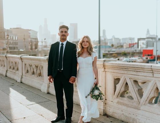 man in black suit standing beside woman in white wedding dress