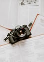 black nikon dslr camera on white printer paper