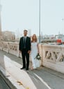 man in black suit standing beside woman in white wedding dress