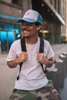 man in white crew neck t-shirt wearing blue cap and black sunglasses