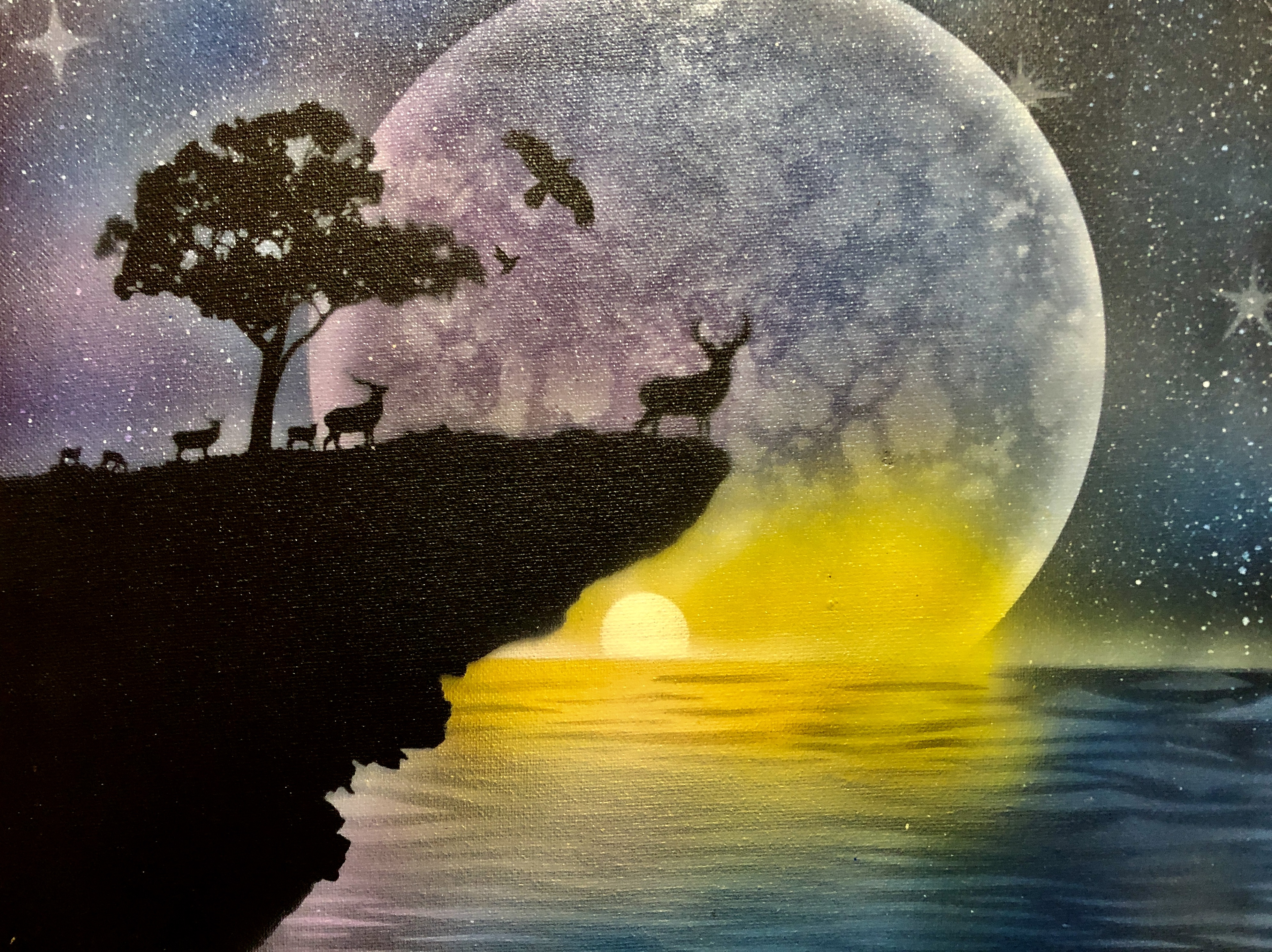 Deer on a cliff overlooking the moon