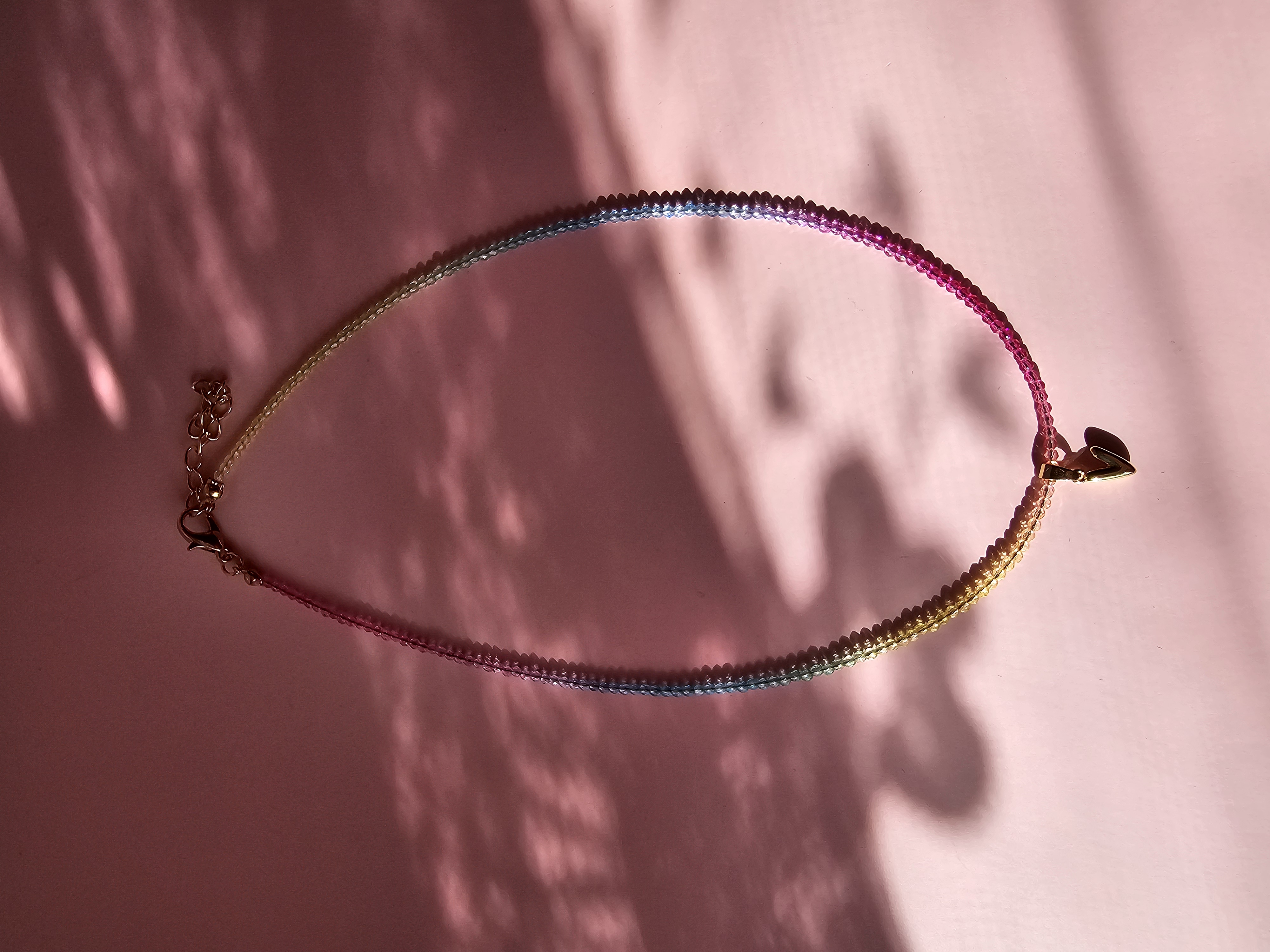 Spalvingas kaklo vėrinys su V raide