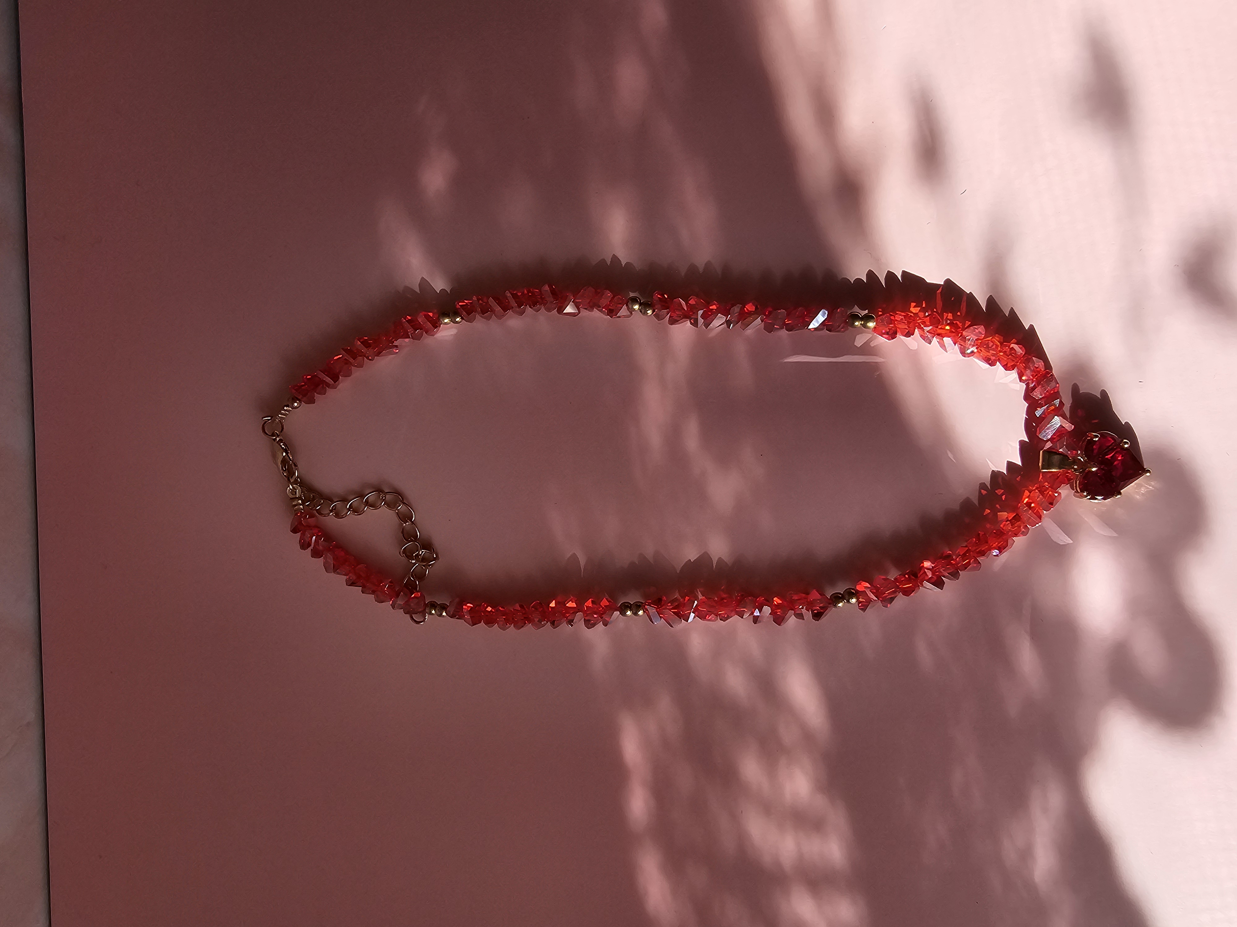 Puošnus raudonas kaklo vėrinys su širdele