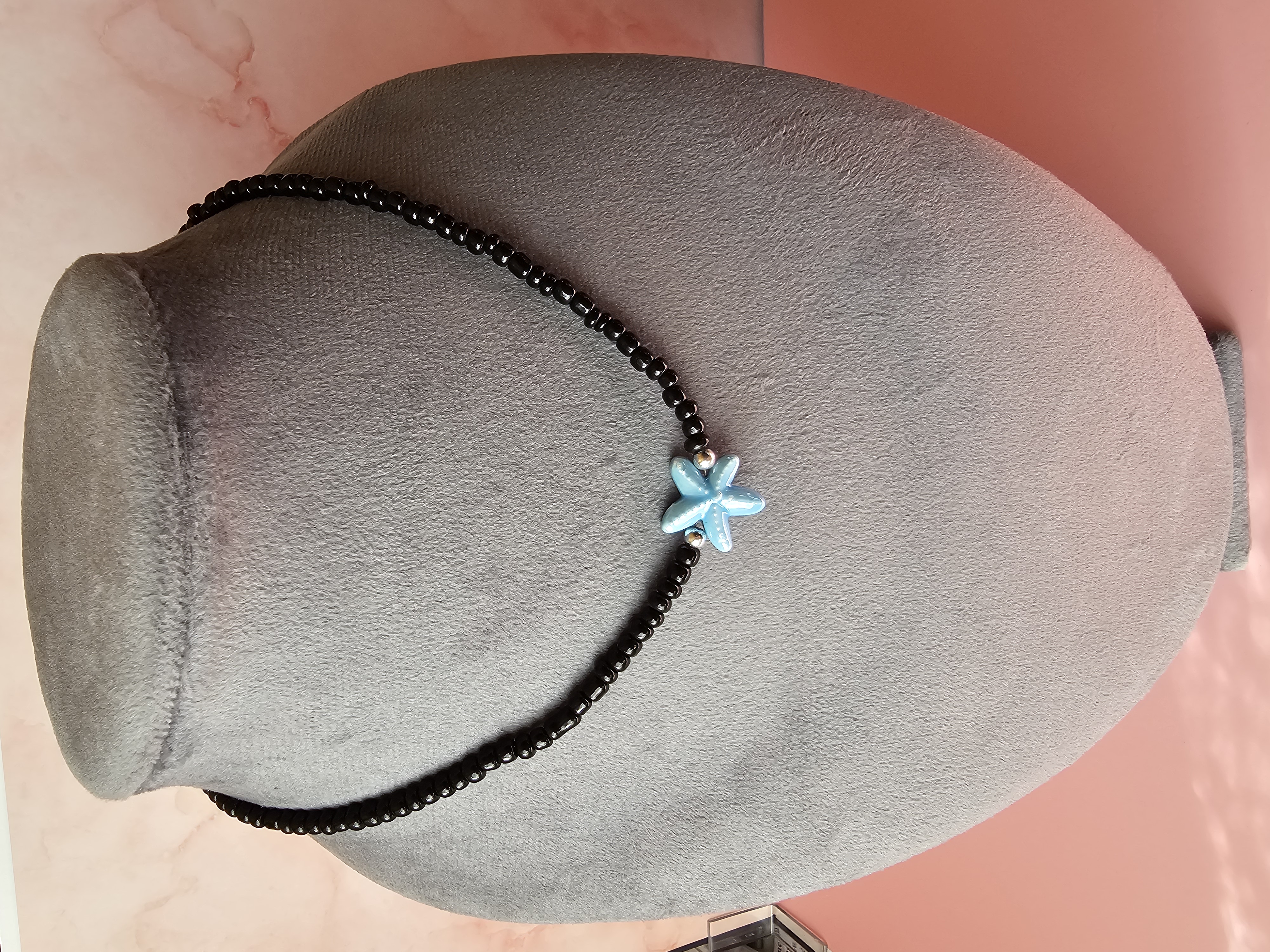 Juodų karoliukų vėrinys su mėlyna žvaigžde