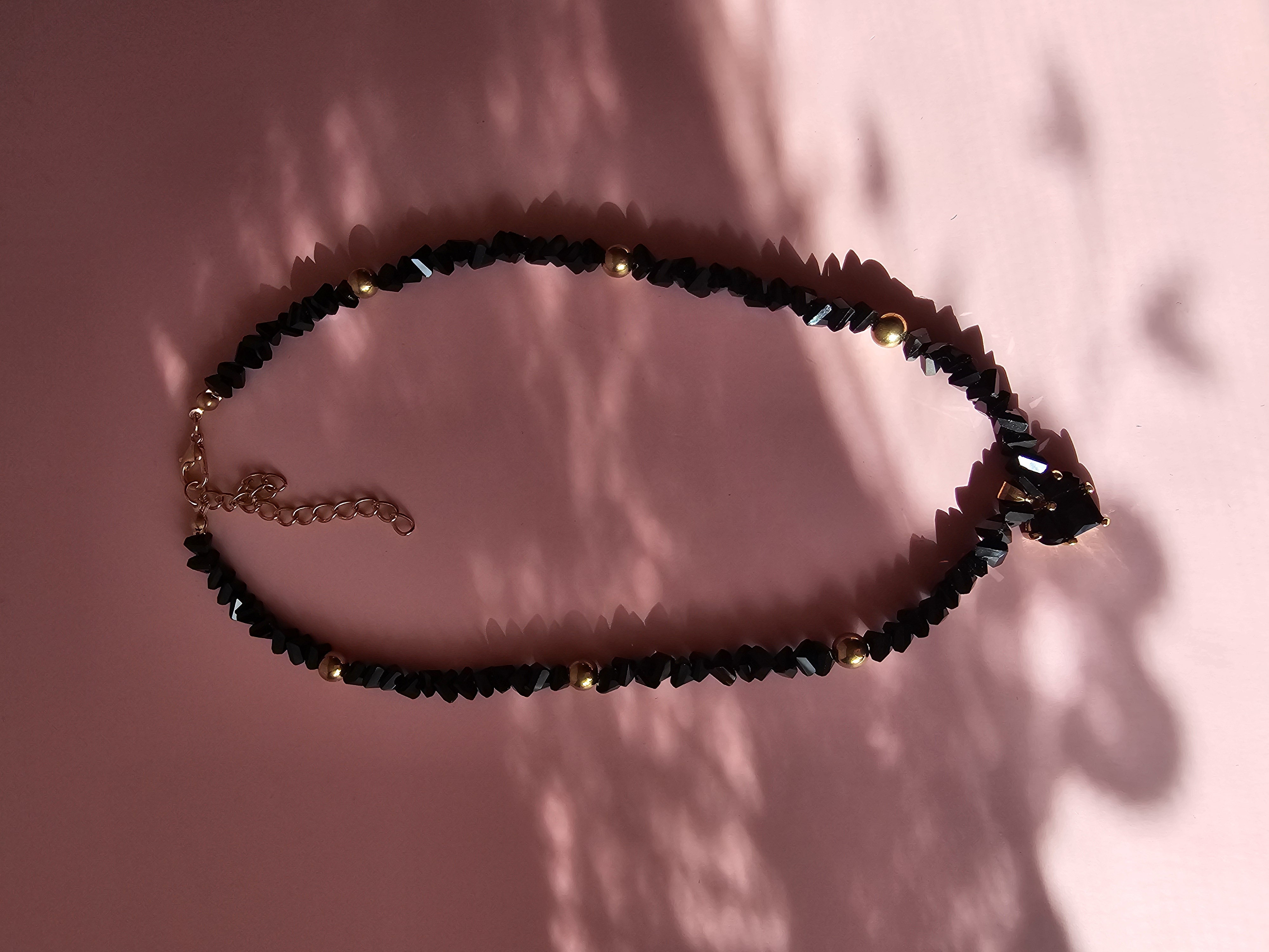 Puošnus juodas kaklo vėrinys su aukso detale ir širdele