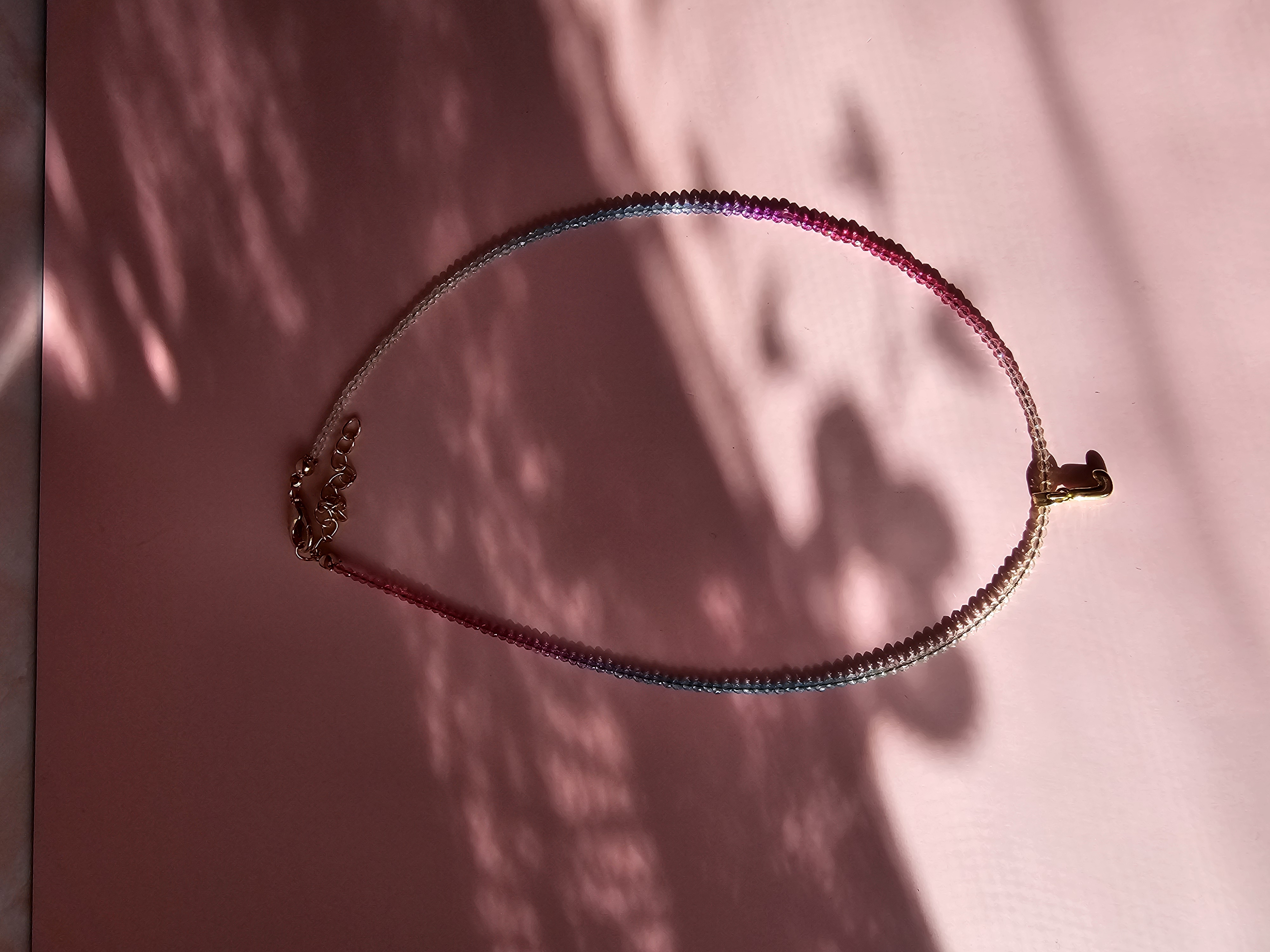 Spalvingas kaklo vėrinys su J raide.