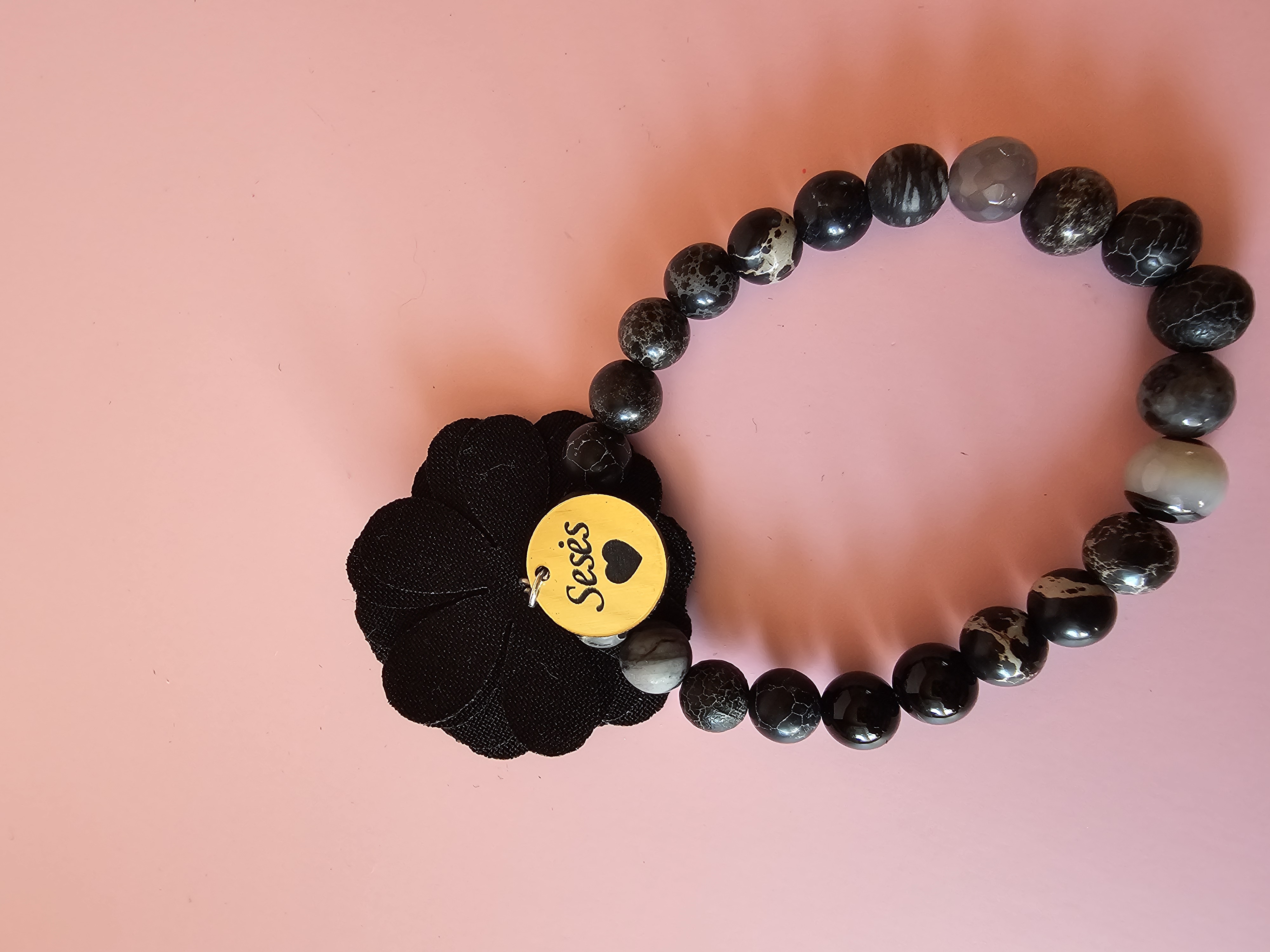 Juoda apyrankė su užrašu "Sesės"