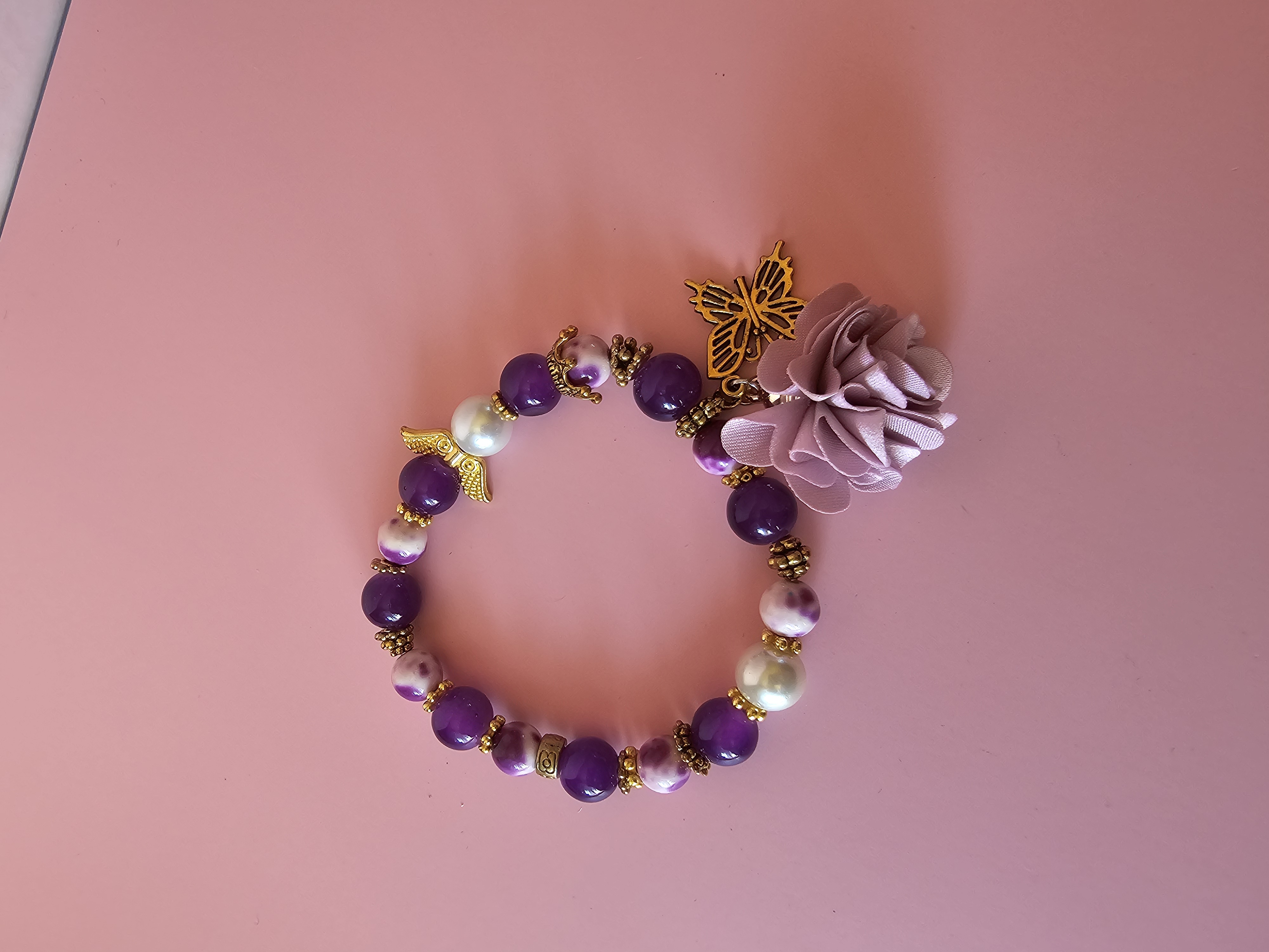 Violetinė apyrankė su gėle ir drugeliu