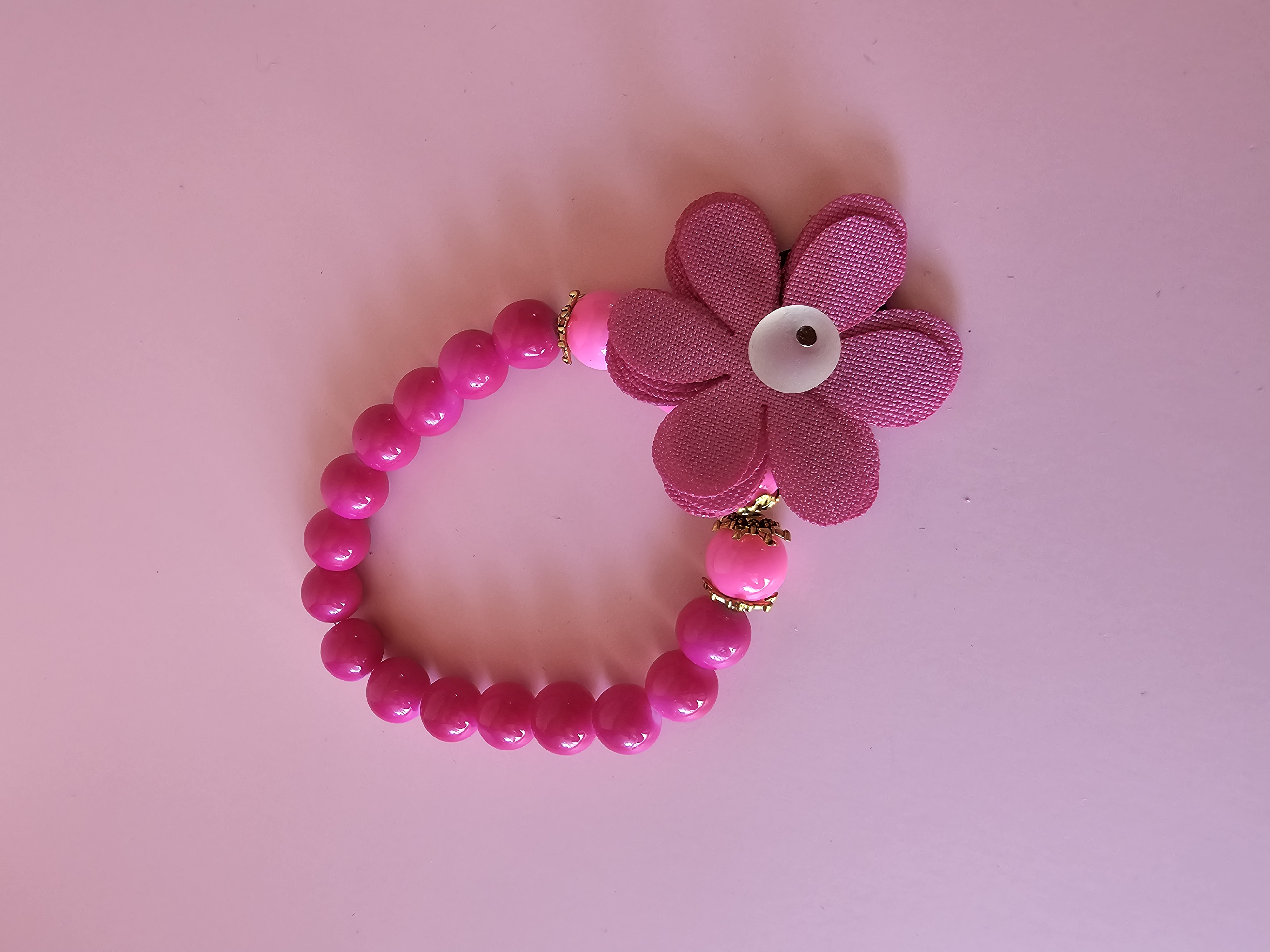 Rožinė apyrankė su ženklu