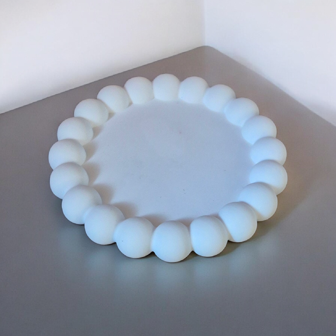 Minimalistinis baltas gipso padėkliukas su karoliukų apvadu“