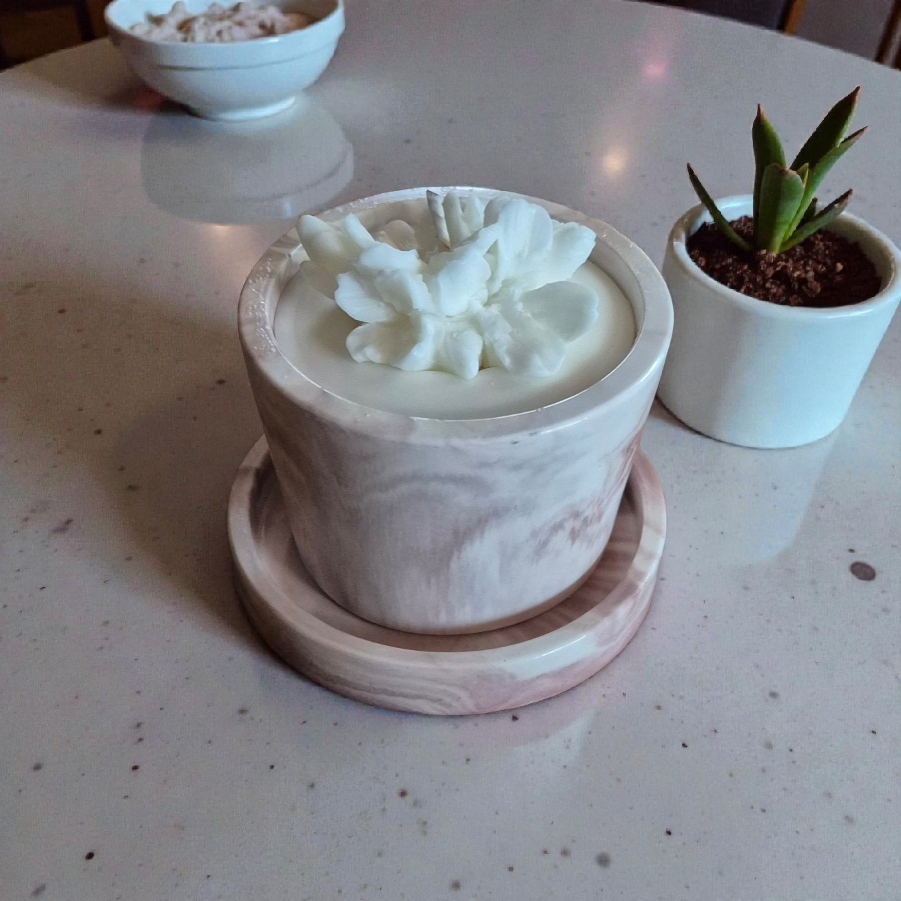 Marmurinė sojų vaško žvakė su gėle ant padėkliuko