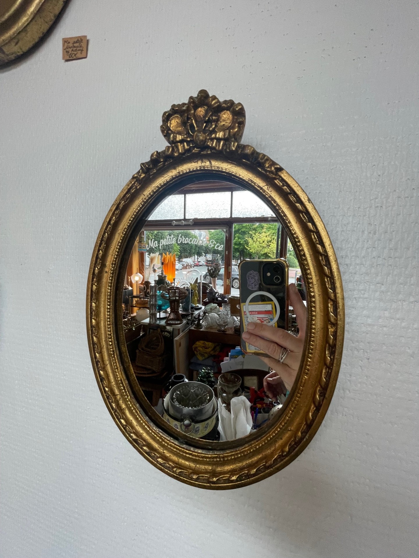 Miroir ovale doré orné d'un noeud