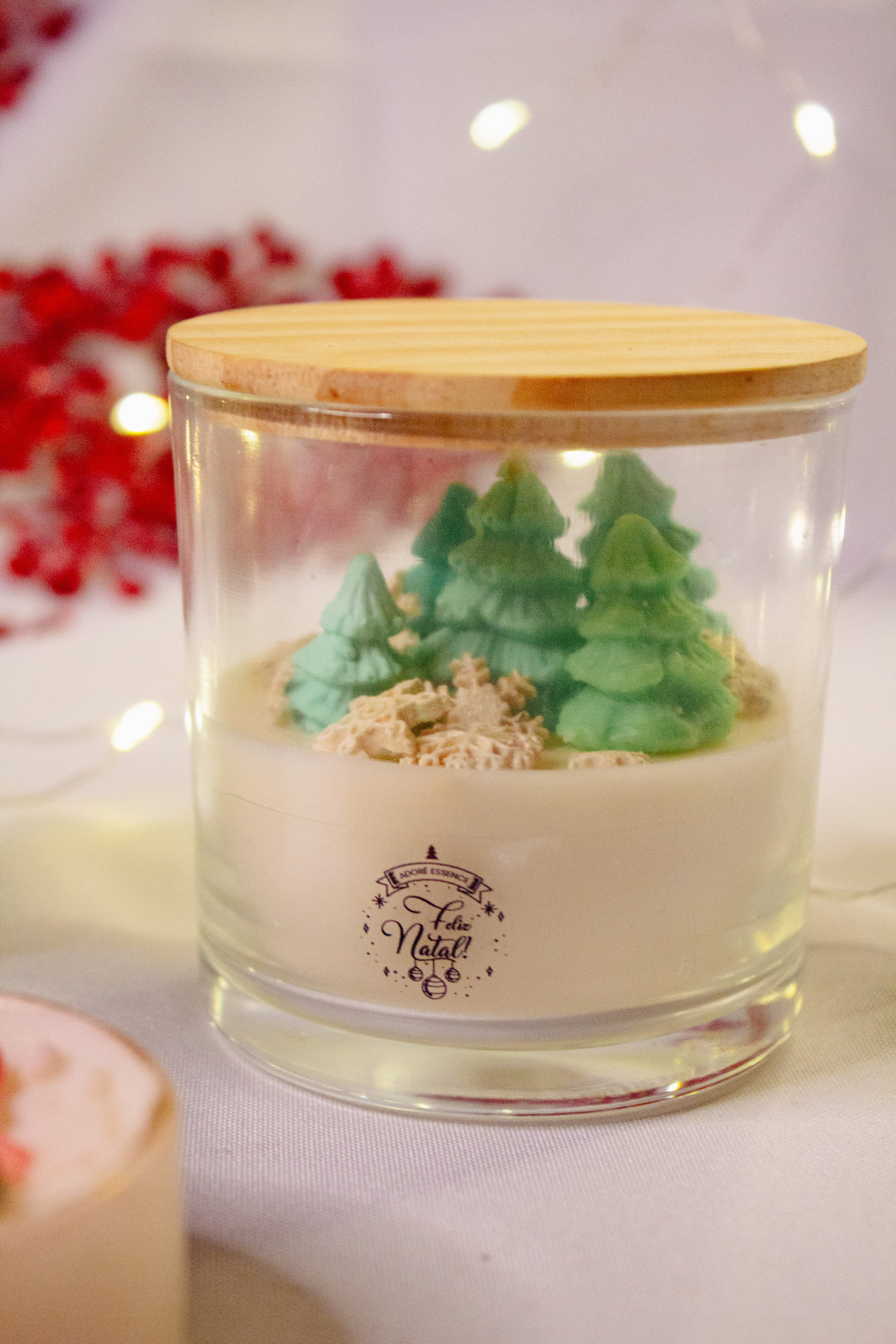 Vela no copo com pinheiros e flocos de neve