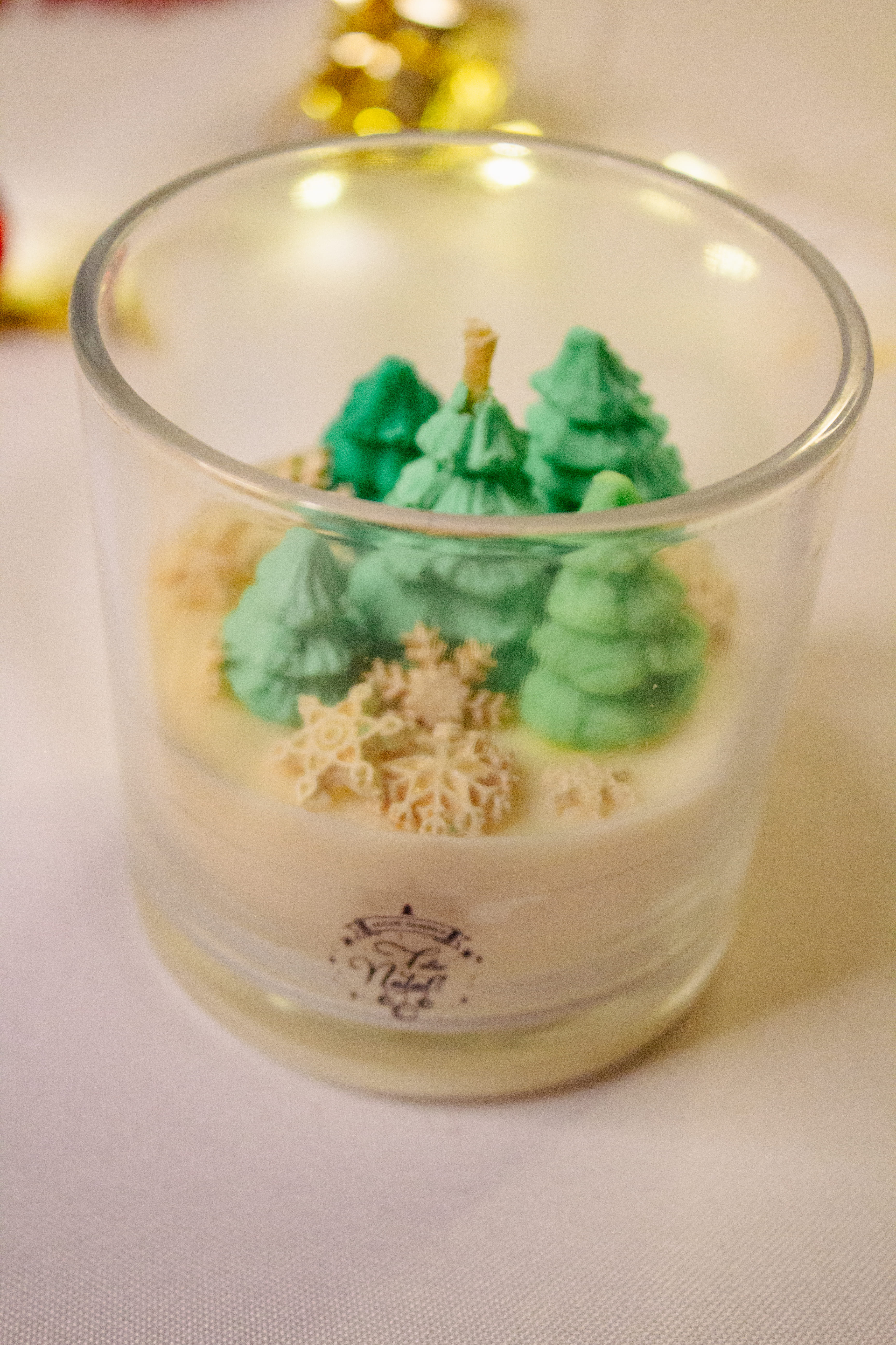 Vela no copo com pinheiros e flocos de neve