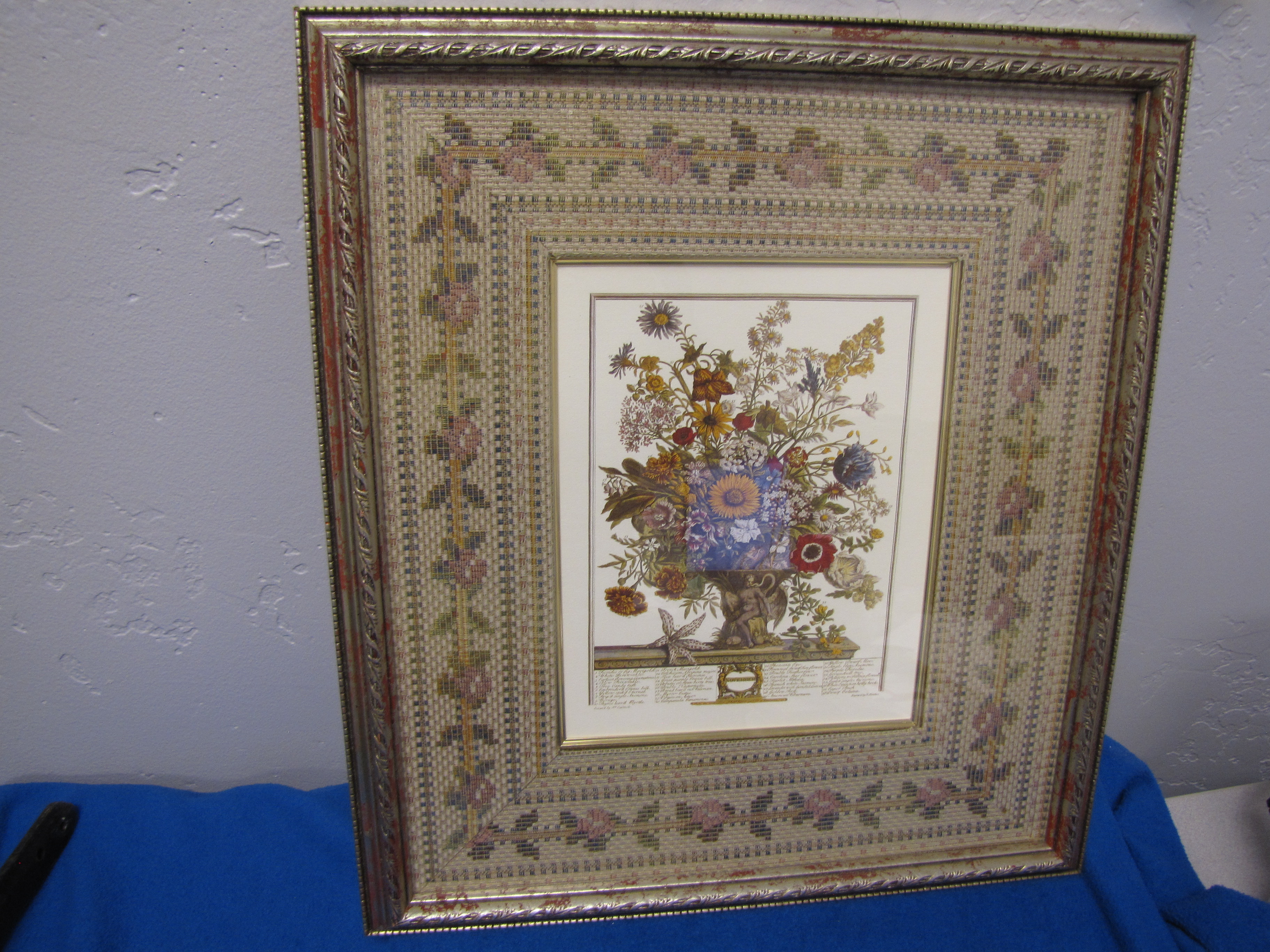 Metal Framed Art Painting of Flowers Surrounded by Designed Woven Cloth