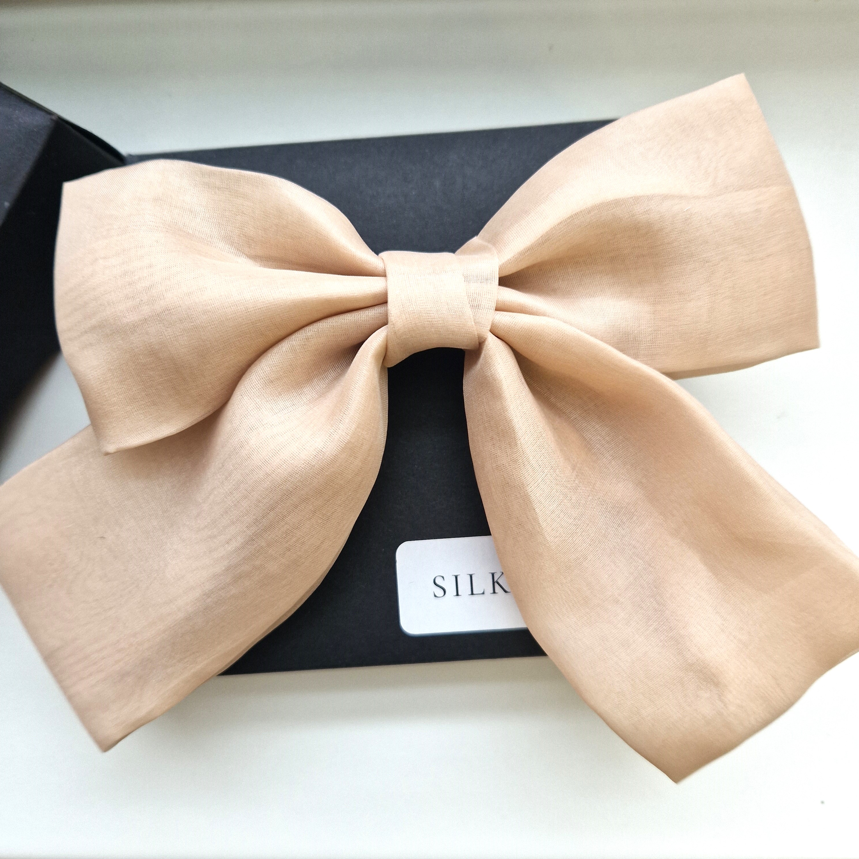 Švelnus persikinis organzos kaspinas