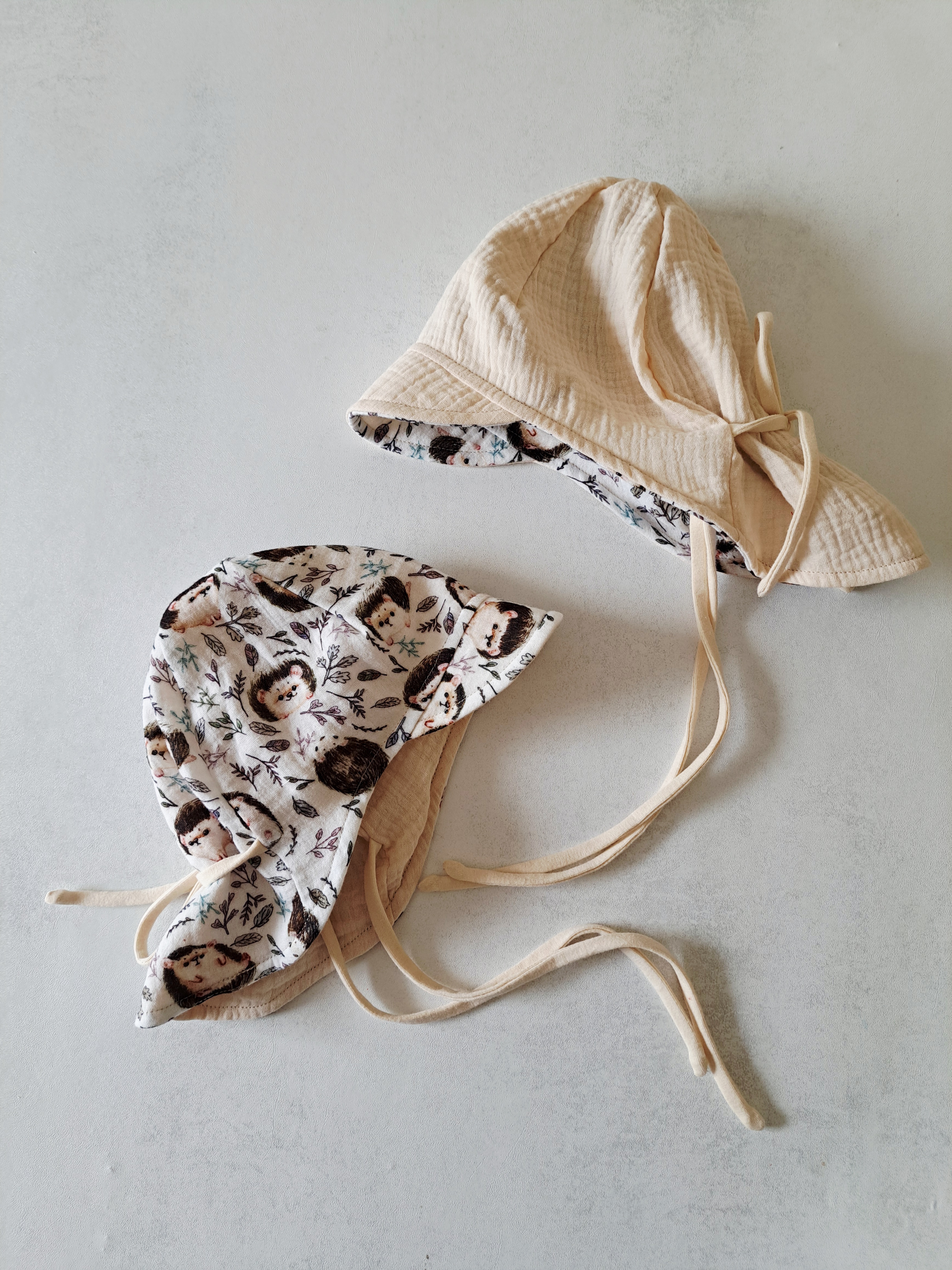 Dvipusė muslino kepurė su snapeliu ir kaklo apsauga