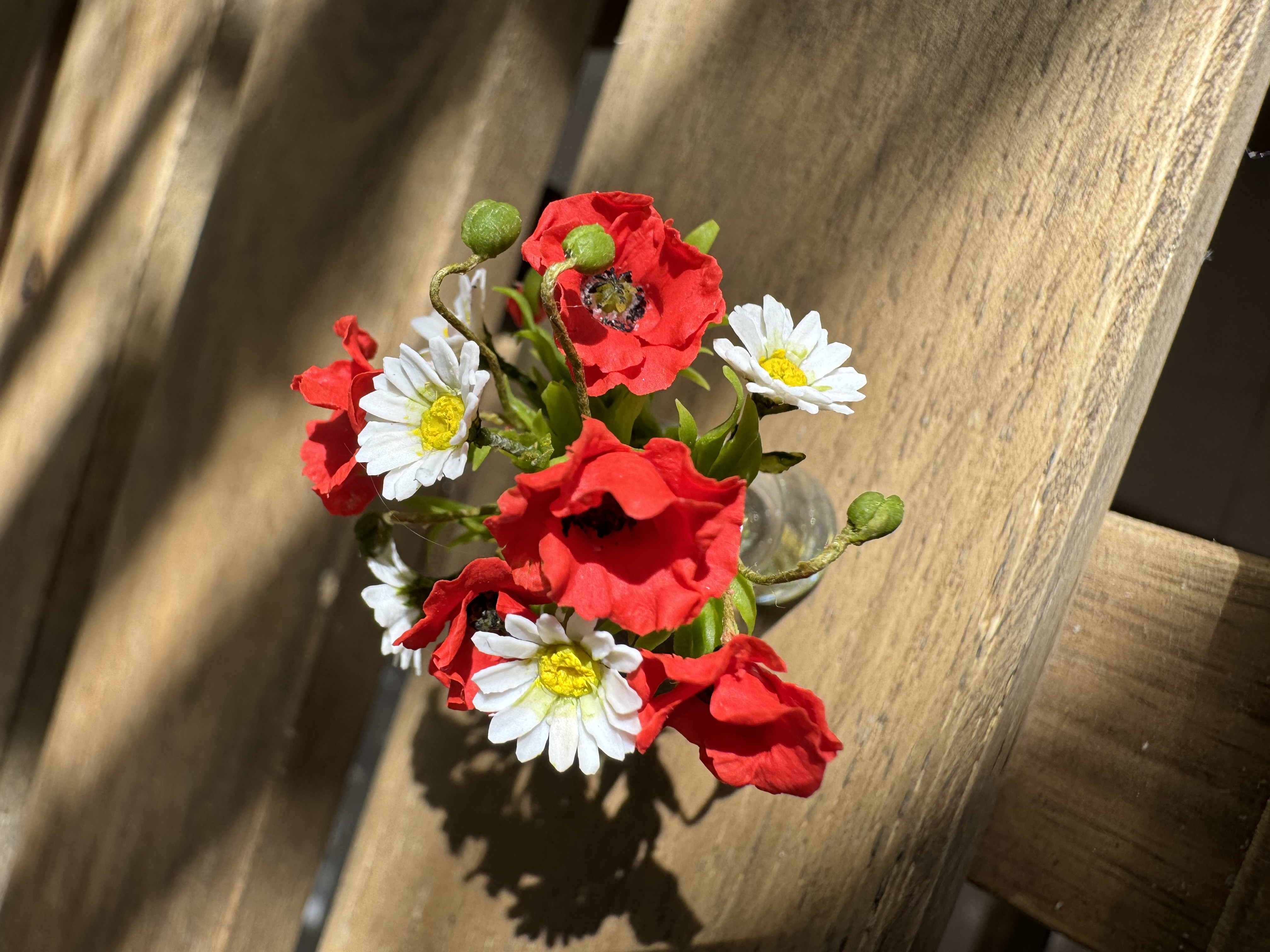 Poppies and daisies in glass vase