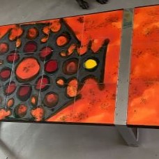 Table basse en céramique à dominante orange, métal et chrome signée Belarti. 